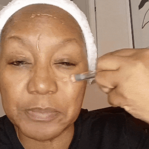 Woman applying the serum with a dropper to her forehead