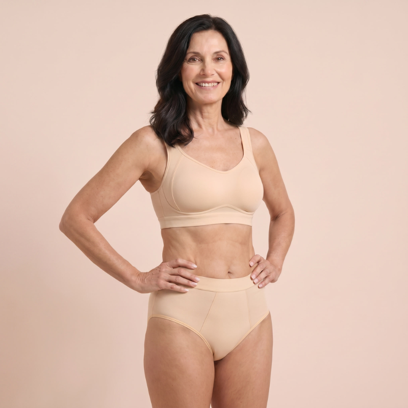 Woman wearing the beige hipster and top against a pink background