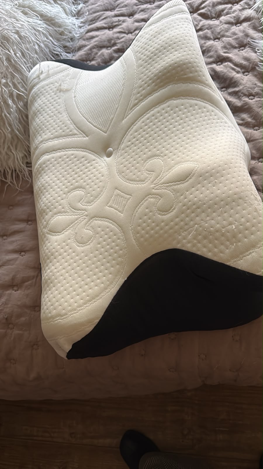 Contoured pillow with textured cover on a bed