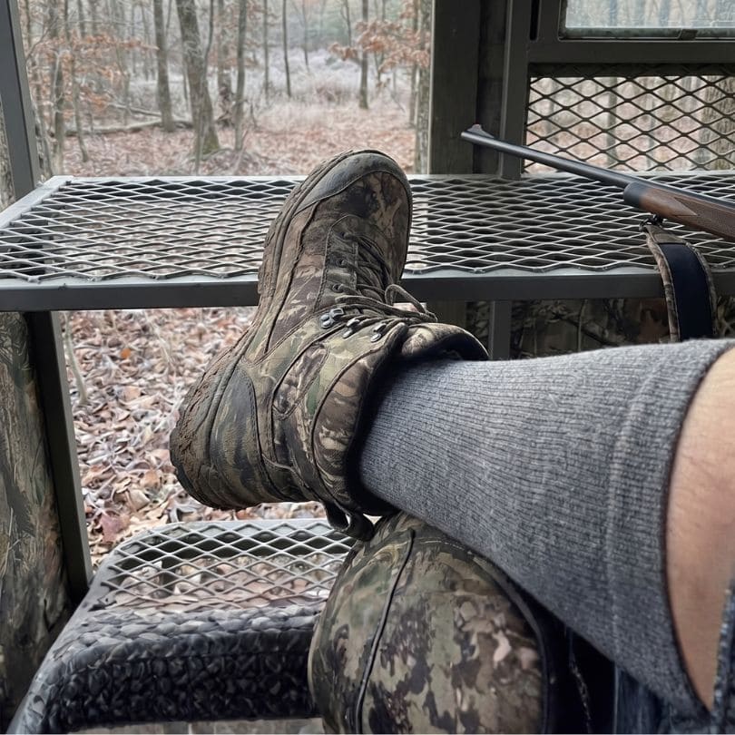 Grey alpaca compression socks worn with camouflage hunting boots