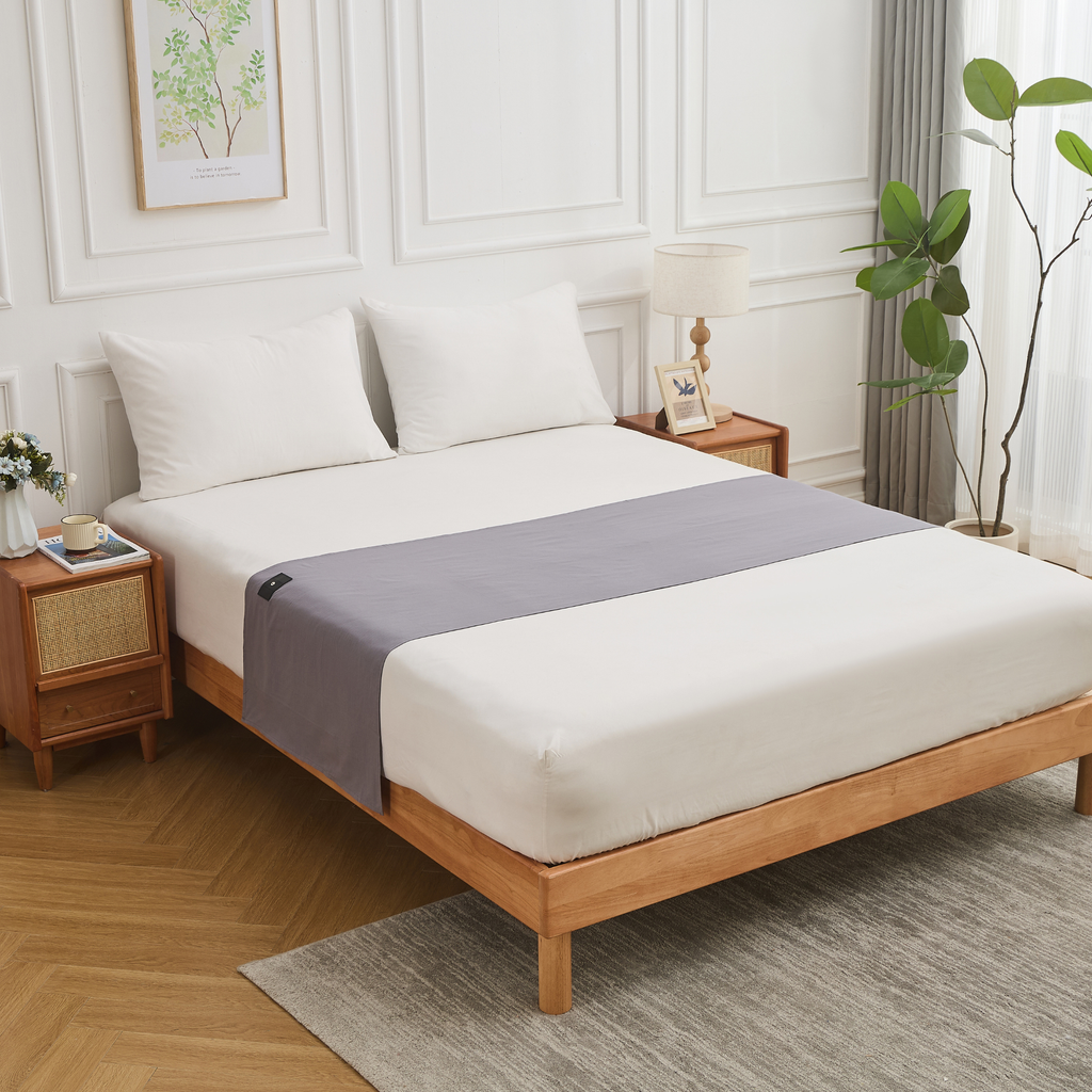 Grounding half bed sheet placed on a wooden bed frame with white bedding.