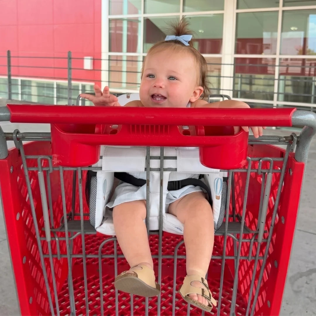 Happy baby in a shopping cart using the padded seat