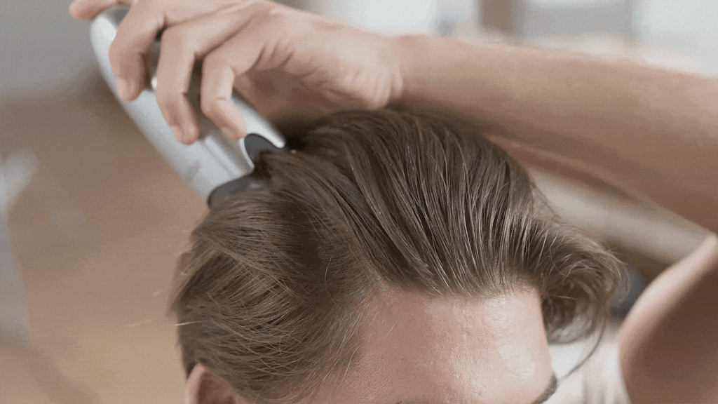 Close-up of the applicator tips parting hair at the hairline