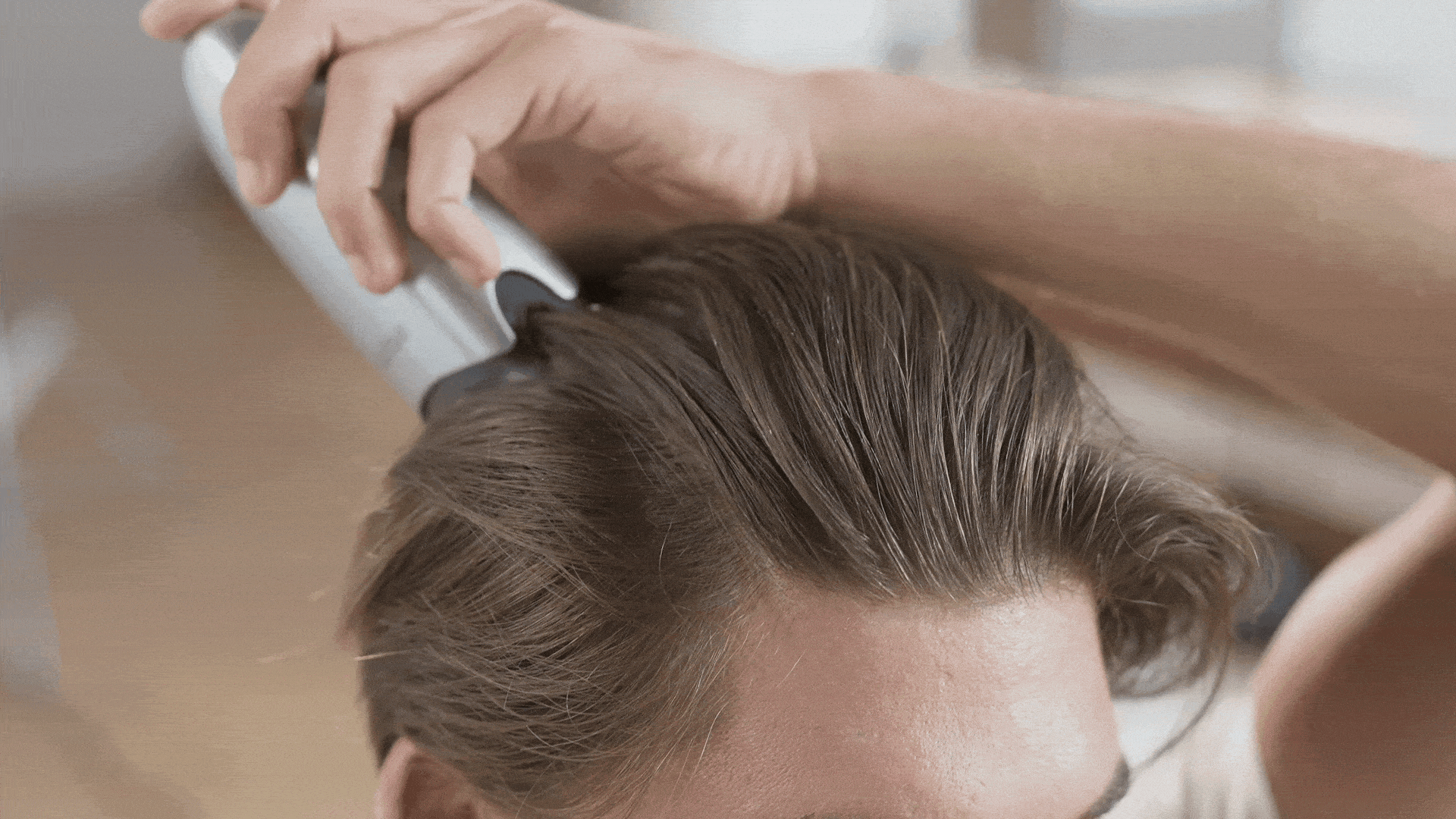 Close-up of the applicator tips parting hair at the hairline