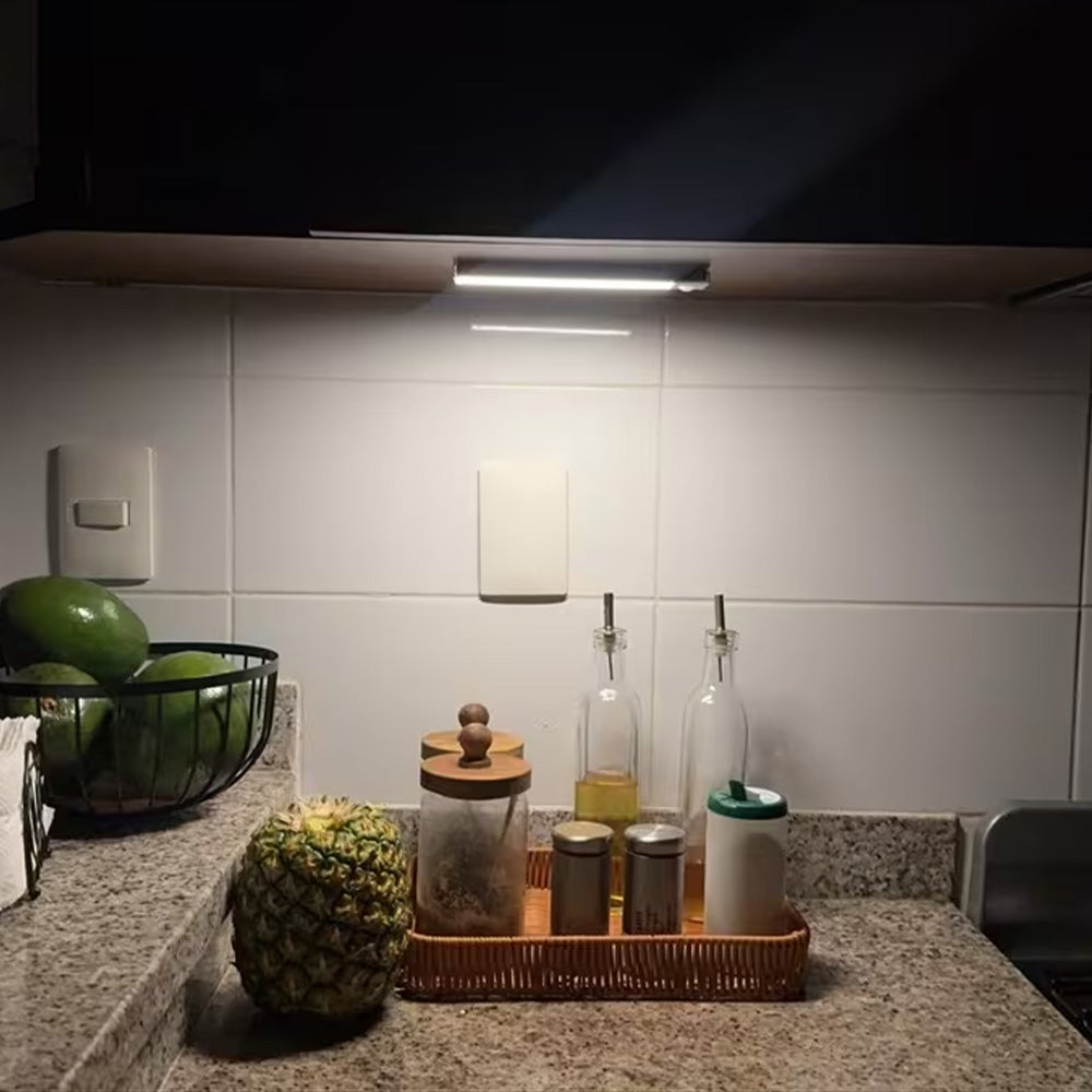 LED light bar glowing under a kitchen cabinet above a countertop