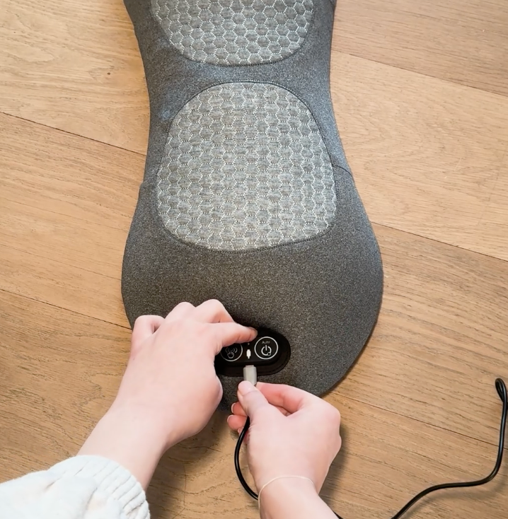 Hand plugging the USB cable into the massager control panel