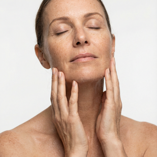 Woman gently pressing her hands to her face and neck