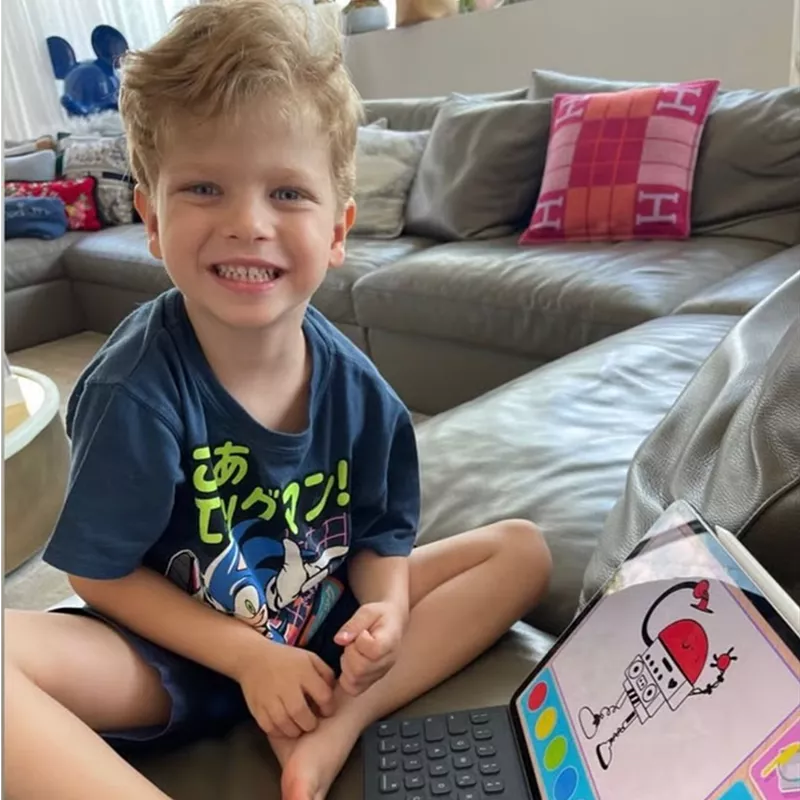 Smiling boy sitting on the sofa at home