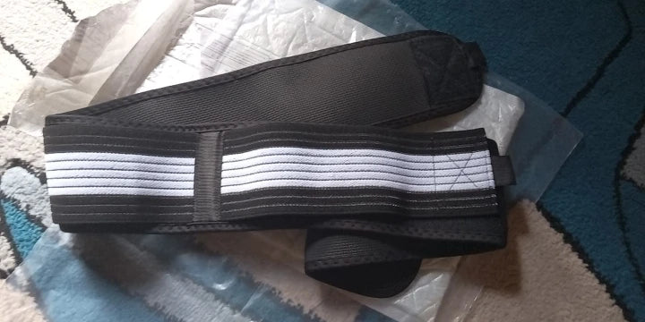 Black hip belt with grey and white elastic tension straps laid flat