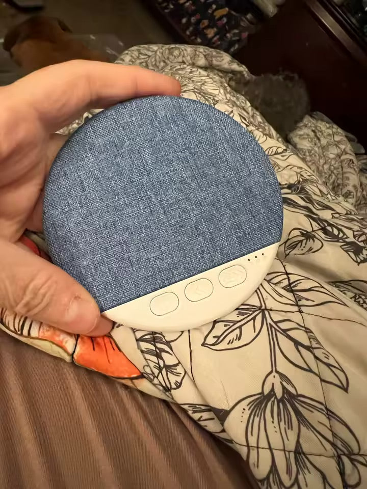 Pillow speaker held in one hand showing its compact size