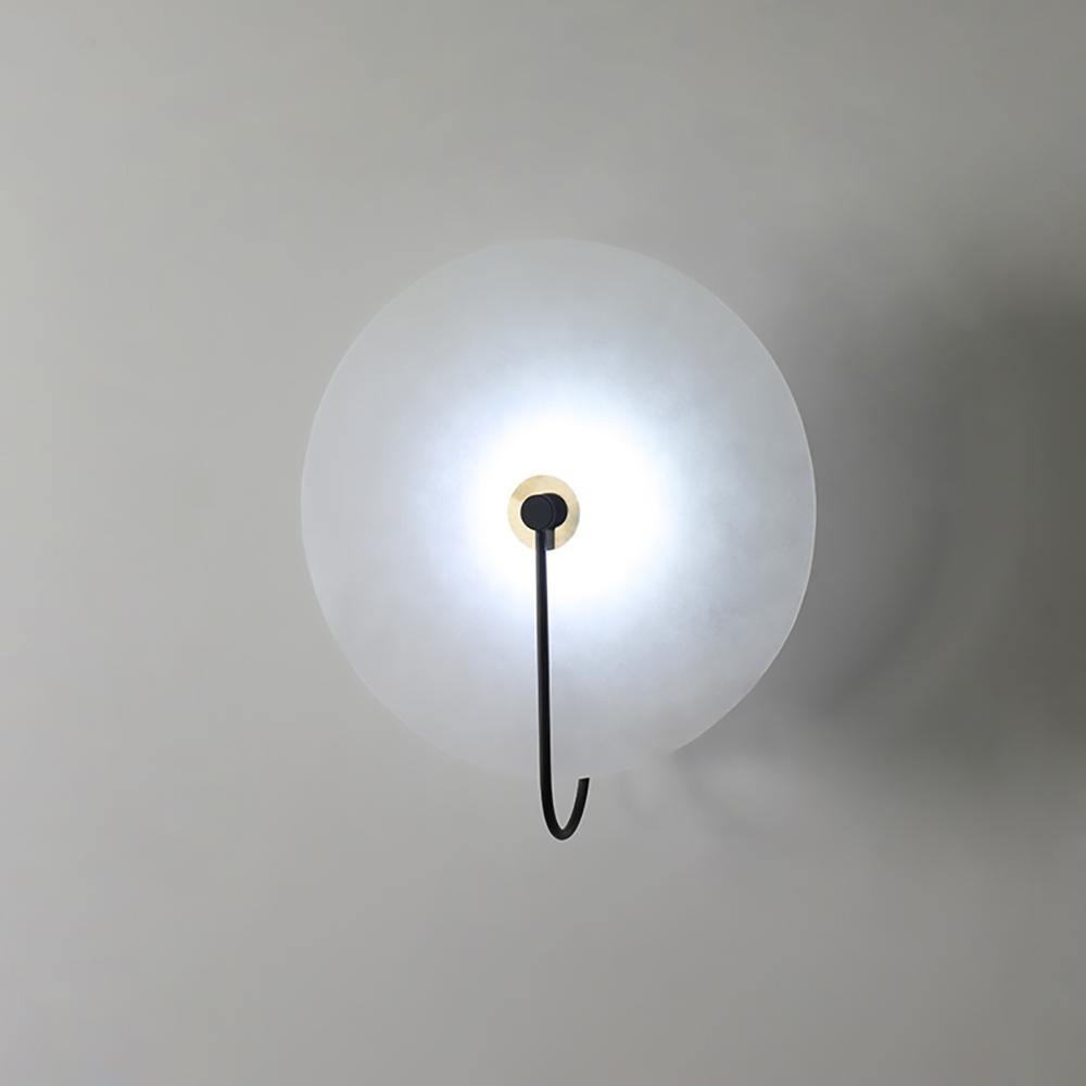 Kristy LED-vägglampa i alabaster — runt snöflingemönster, smal svart arm
