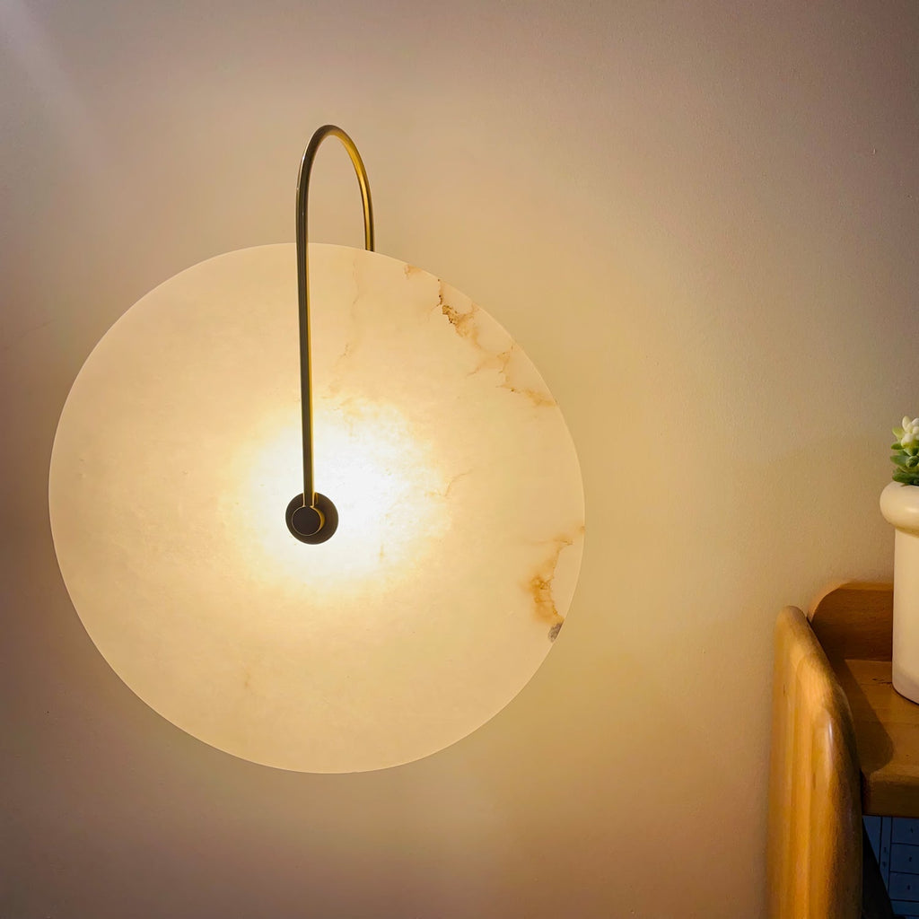 Kristy LED-vägglampa i alabaster — runt snöflingemönster, smal svart arm