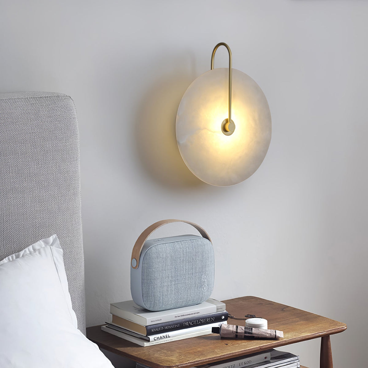 Kristy LED-vägglampa i alabaster — runt snöflingemönster, smal svart arm