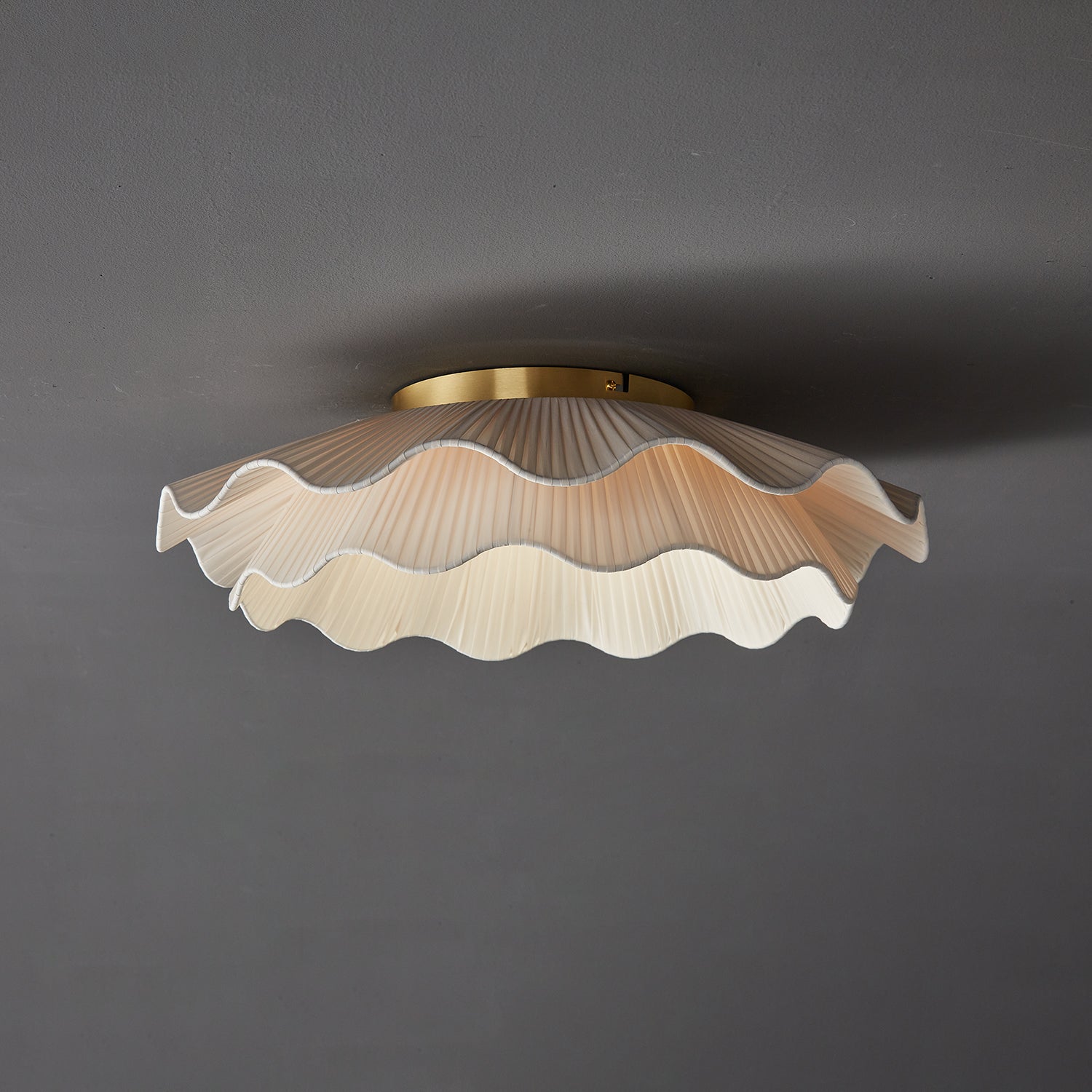 Stropní lampa Arwen s vlnitým plisovaným látkovým stínidlem zakřiveného tvaru