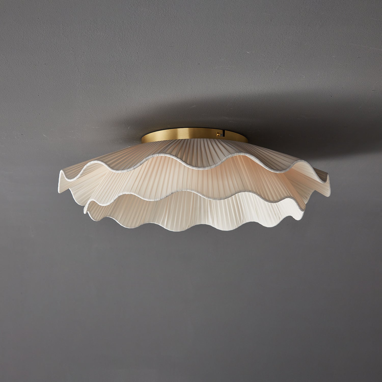 Stropní lampa Arwen s vlnitým plisovaným látkovým stínidlem zakřiveného tvaru