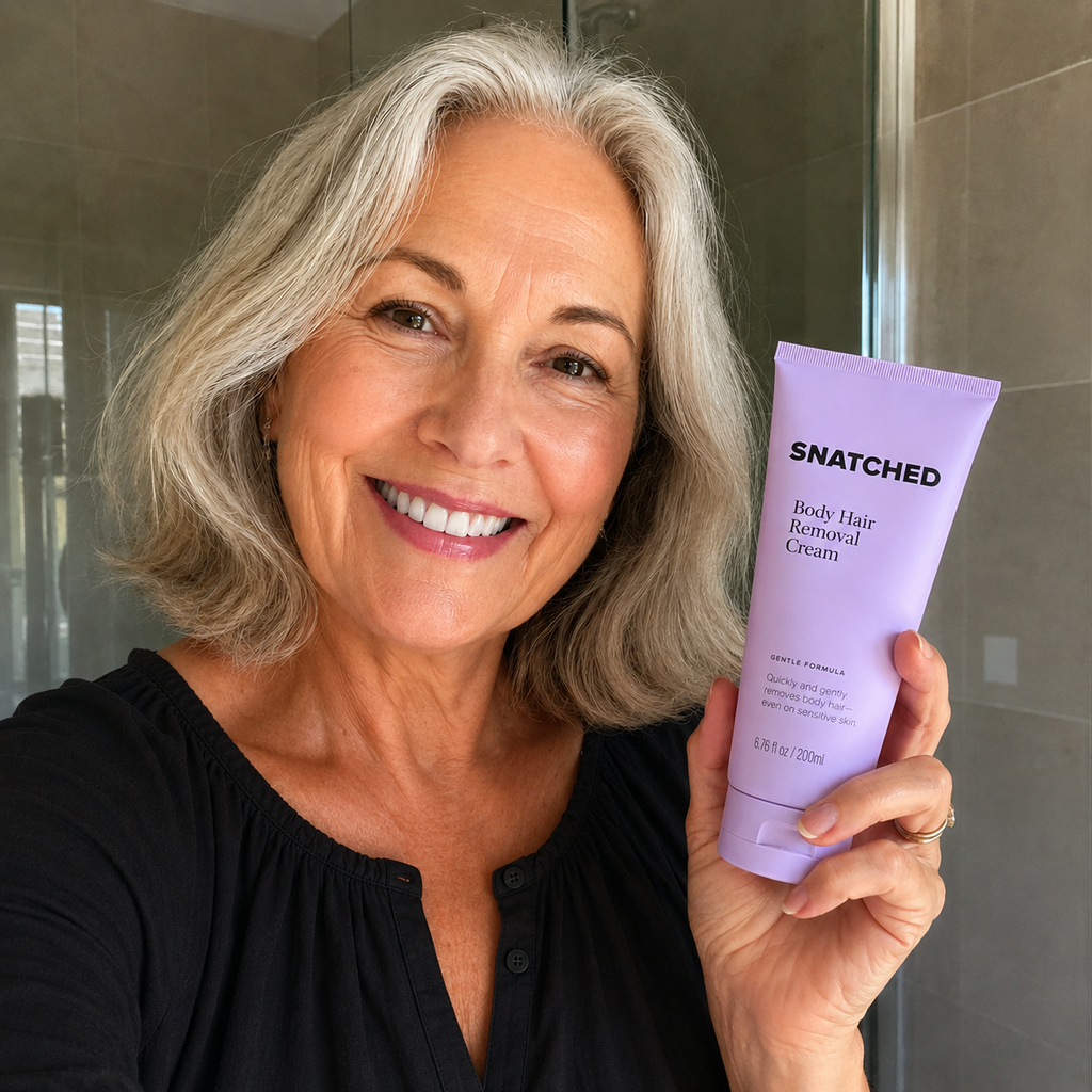 Woman with silver hair smiling and holding the cream