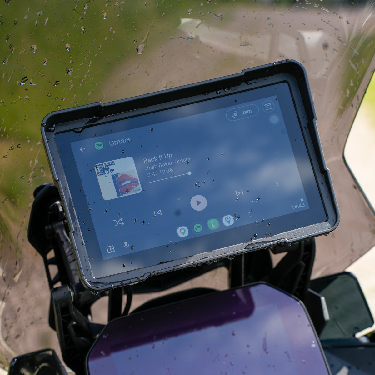 Motorcycle smart display mounted on the handlebars showing a phone projection screen