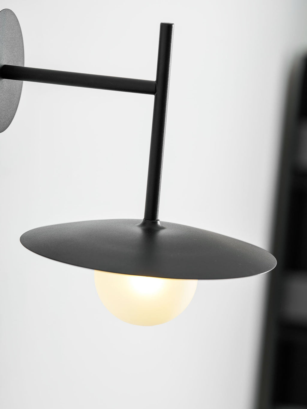 Nástěnné svítidlo Gea z železa — kompaktní zakřivený design