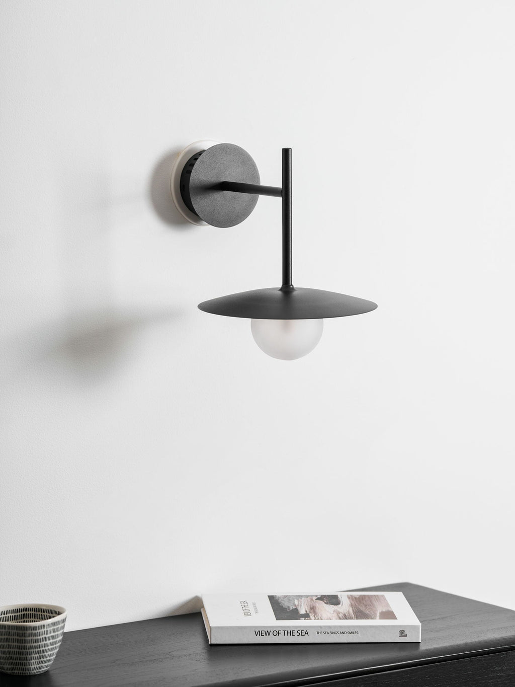 Nástěnné svítidlo Gea z železa — kompaktní zakřivený design