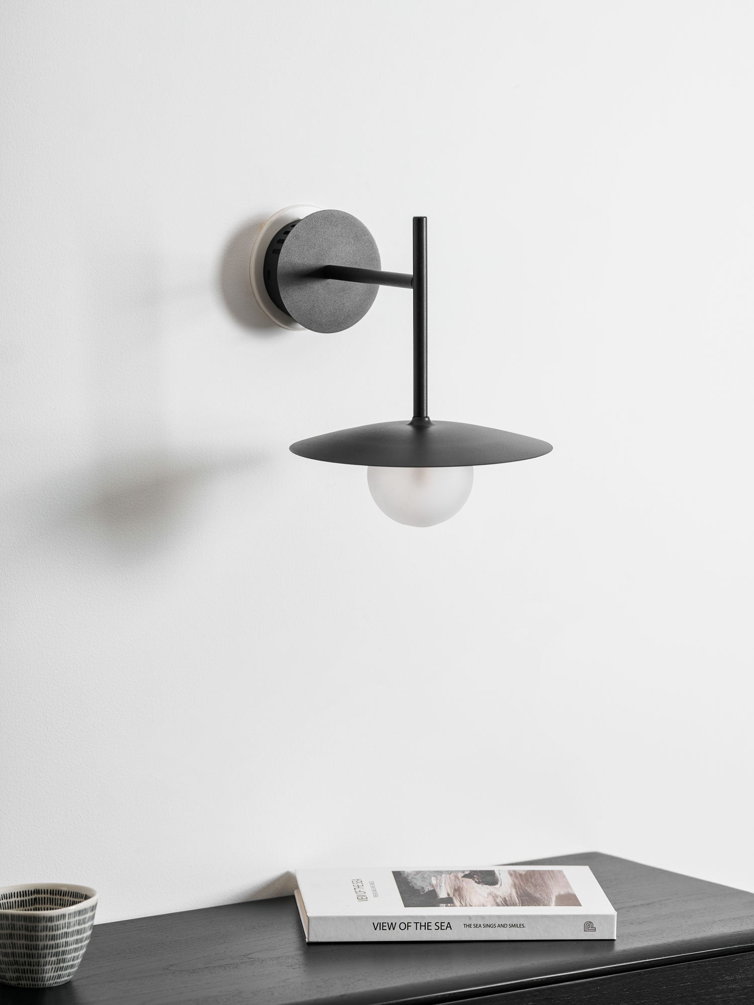 Nástěnné svítidlo Gea z železa — kompaktní zakřivený design