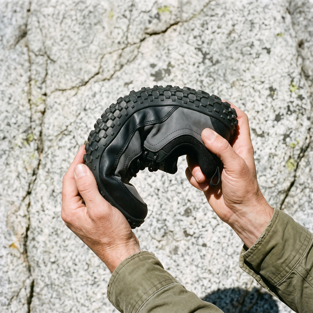 Hands twisting the shoe to show how flexible the lugged sole is