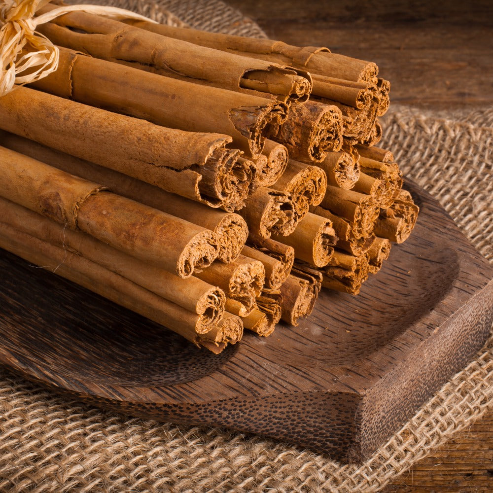 Bundle of rolled Ceylon cinnamon quills on a wooden board