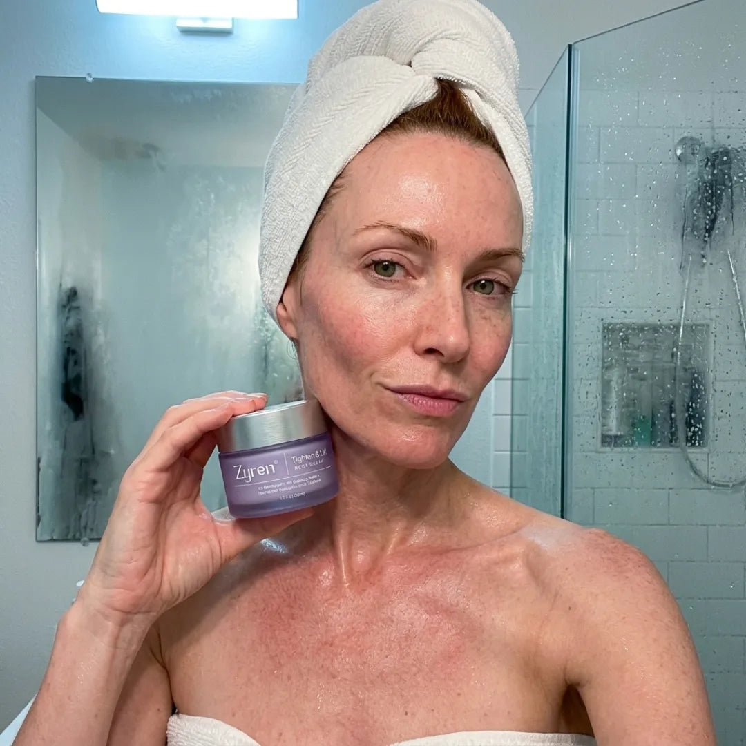 Woman in a bathroom applying neck cream