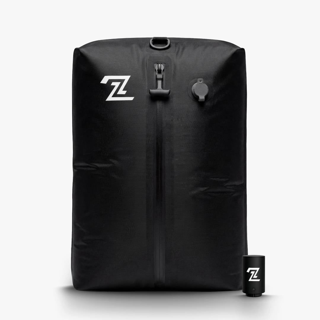 Black travel compression bag standing upright next to its small electric pump