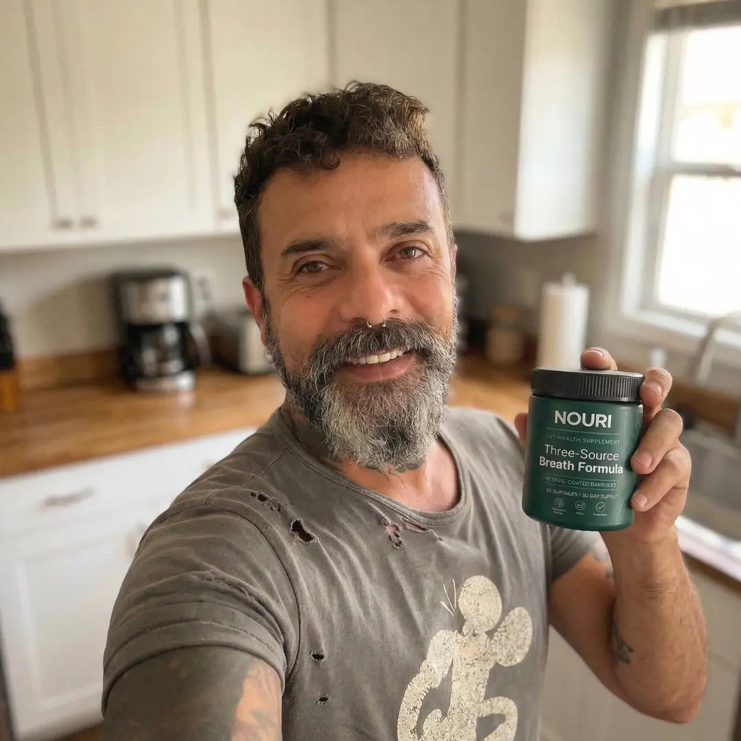 Man in his kitchen holding the jar of capsules