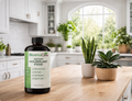 Bottle of liquid houseplant food on a kitchen counter next to potted plants