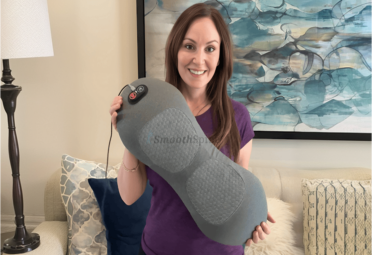 Woman on a sofa showing the massager with its cable attached