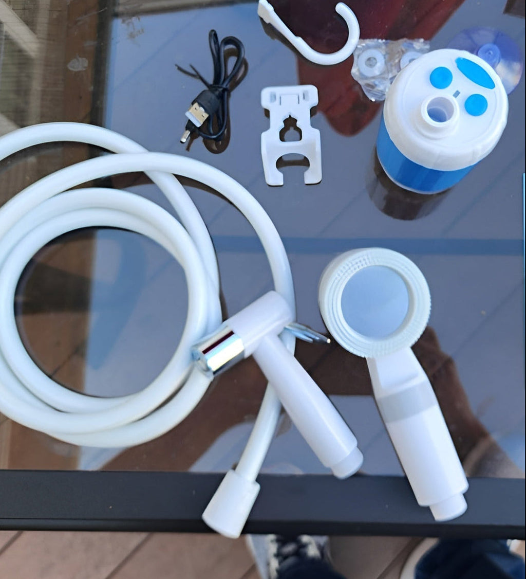 Kit contents laid out: pump, hose, shower head, mount and charging cable