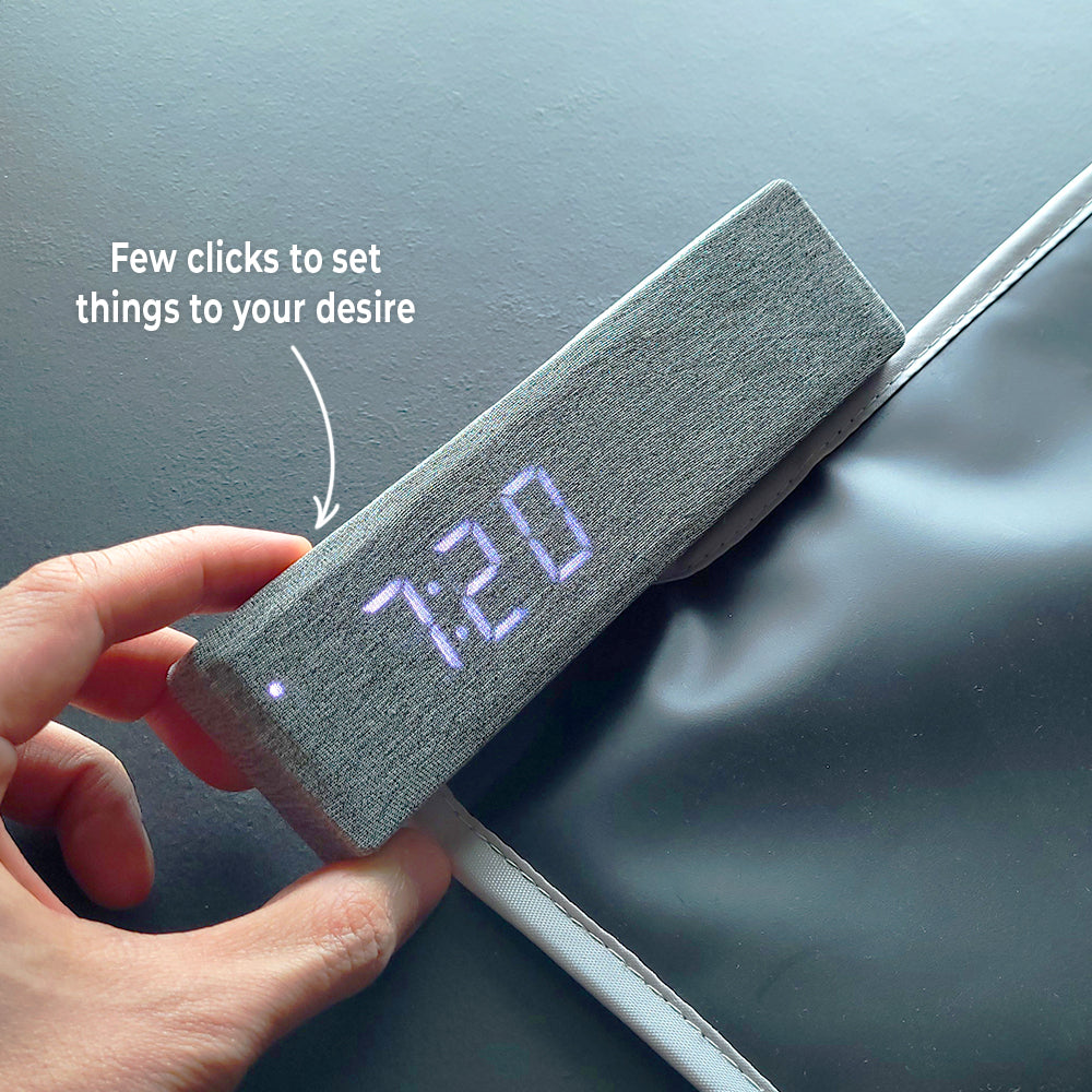 Hand pressing the buttons on the alarm control unit with the time displayed