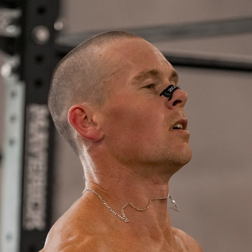 Athlete in the gym breathing through his nose with a black strip