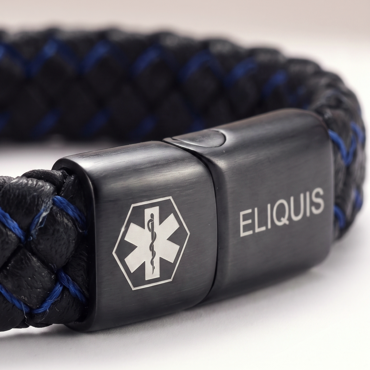 Close-up of the ELIQUIS plate on the black and blue bracelet
