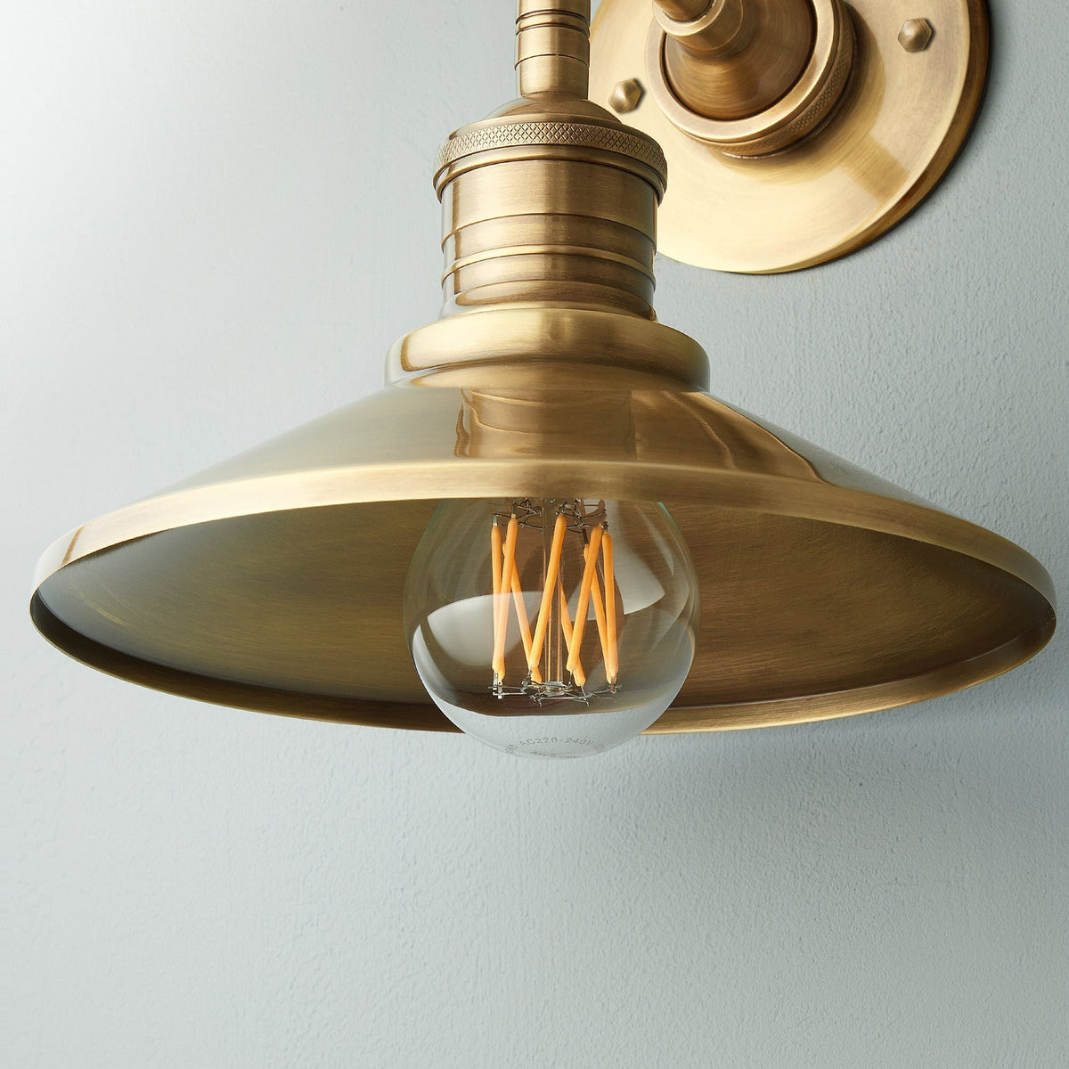 Applique da interno in ottone Isadora — paralume conico, lampadina a vista