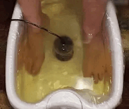 Feet resting in a warm foot bath with the ionizer array in the middle