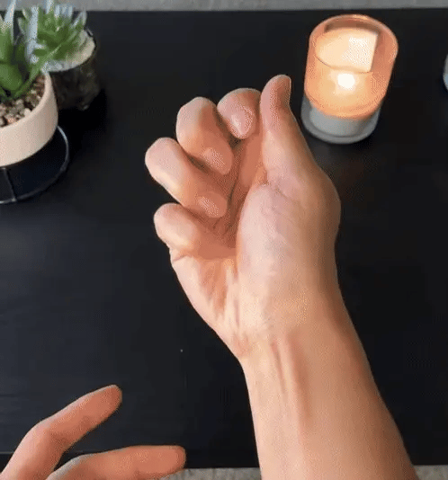Hand gently opening its fingers at a table