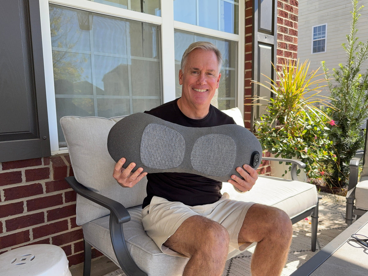 Man on a patio chair holding the lower back massager