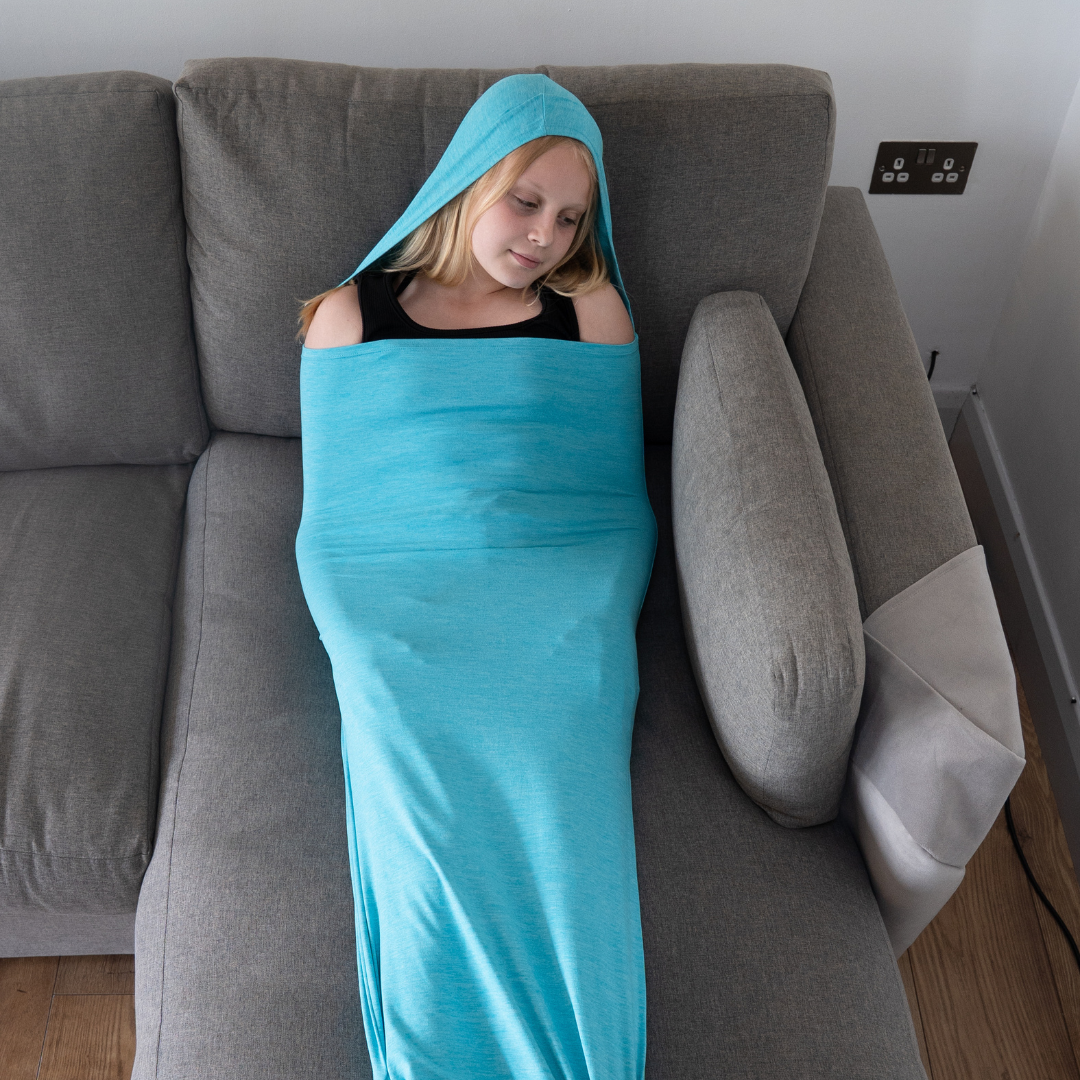 Girl lying on a sofa inside a teal sensory pod