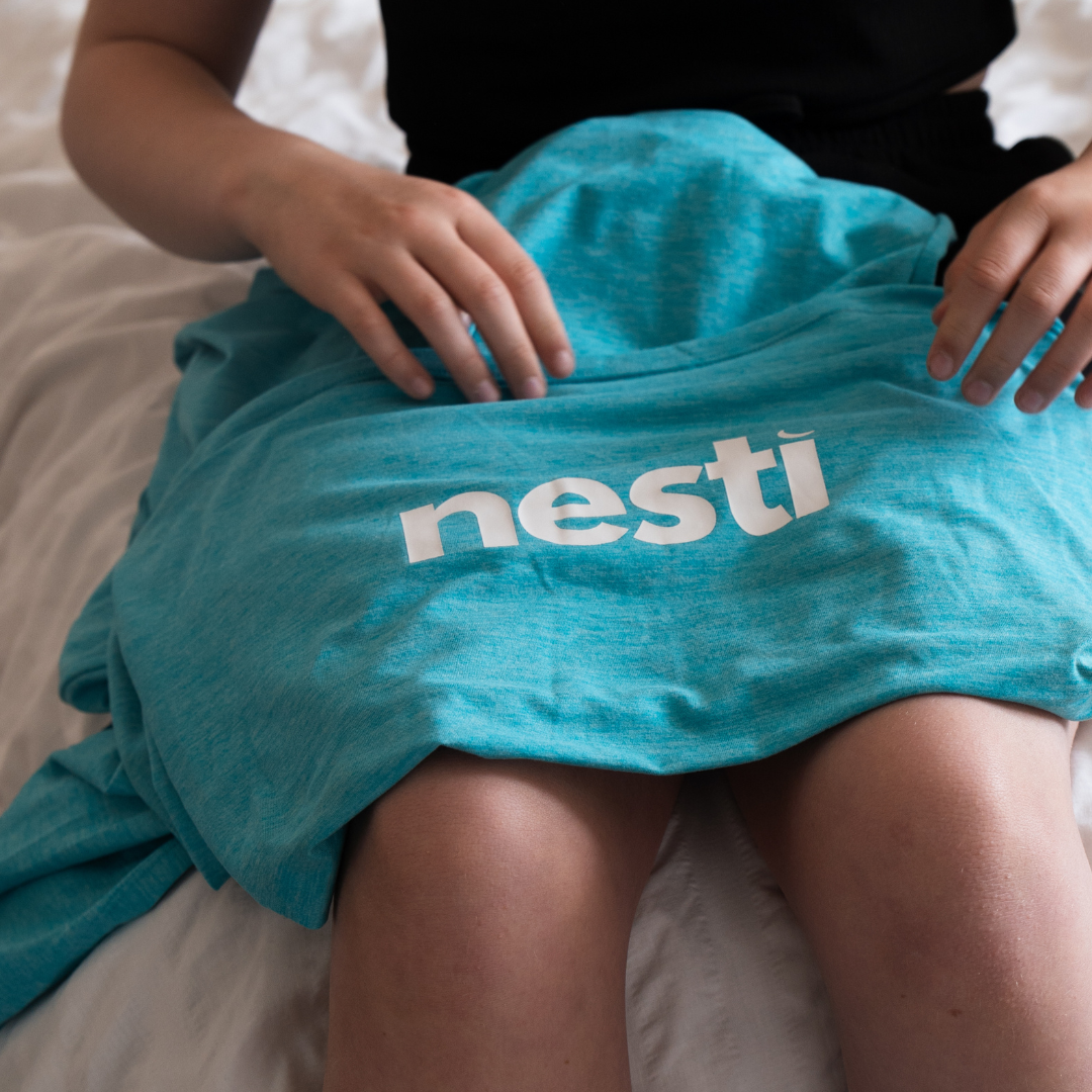 Teal sensory pod fabric resting on a lap