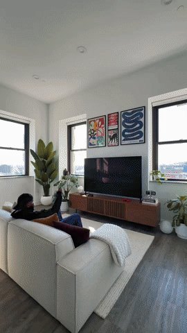 Bright modern living room with a sofa facing a wall-mounted TV