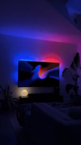 Living room at night with a TV glowing blue and pink on the wall