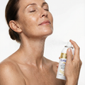 Woman spraying the collagen mist onto her neck
