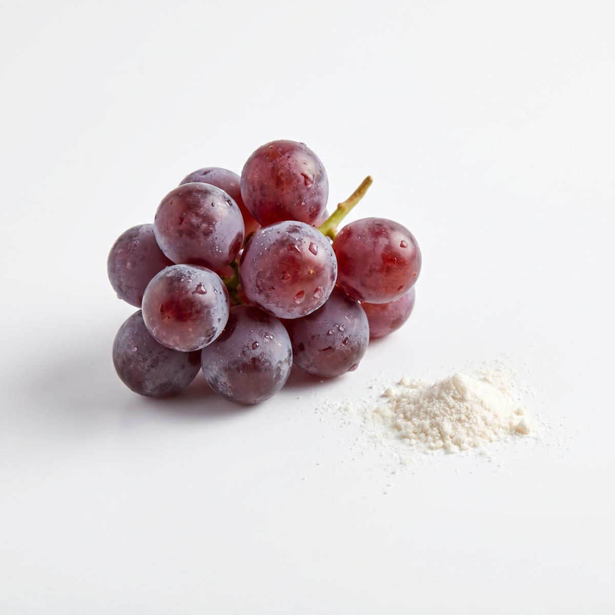 Red grapes next to a small pile of powder