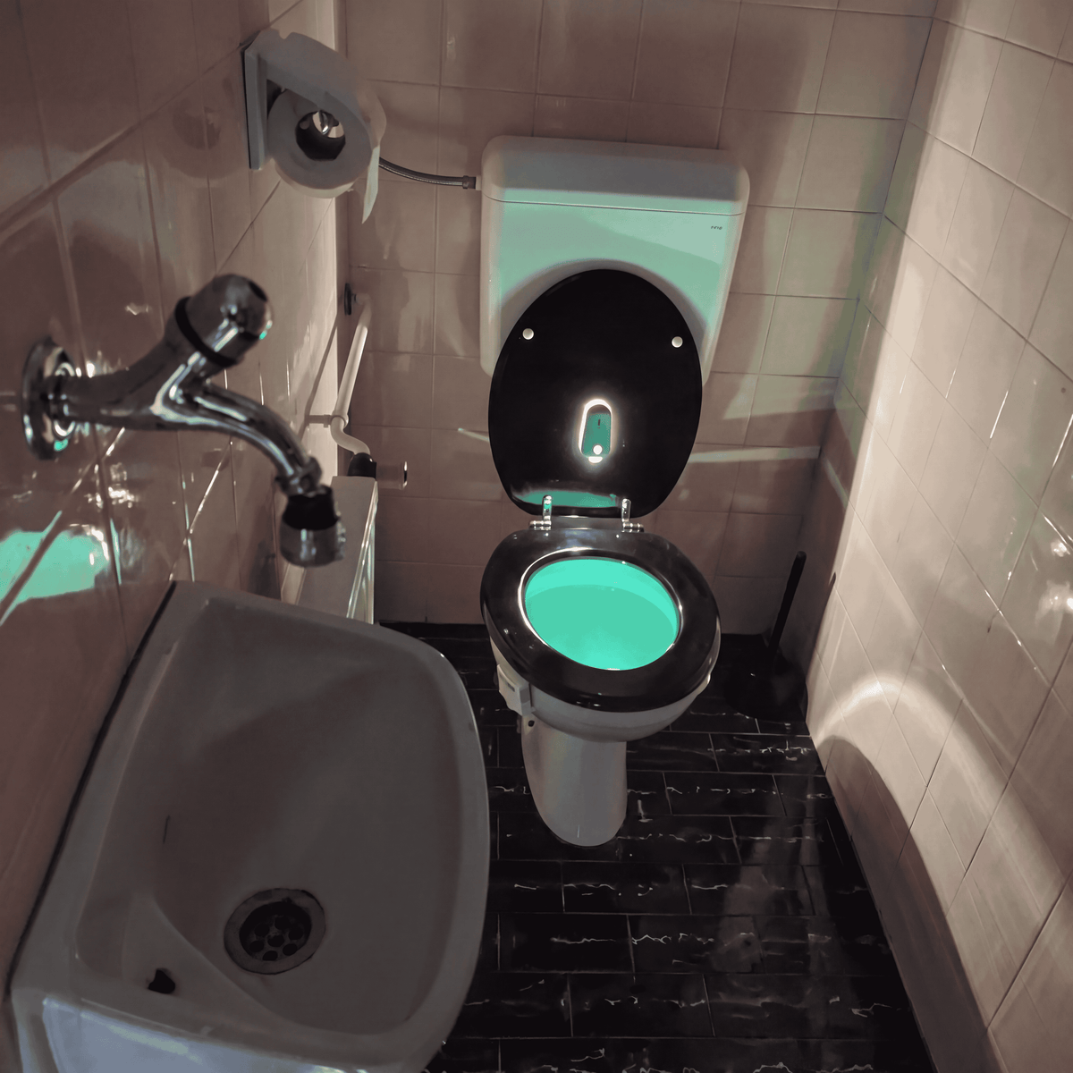 Night light glowing inside a toilet in a real bathroom