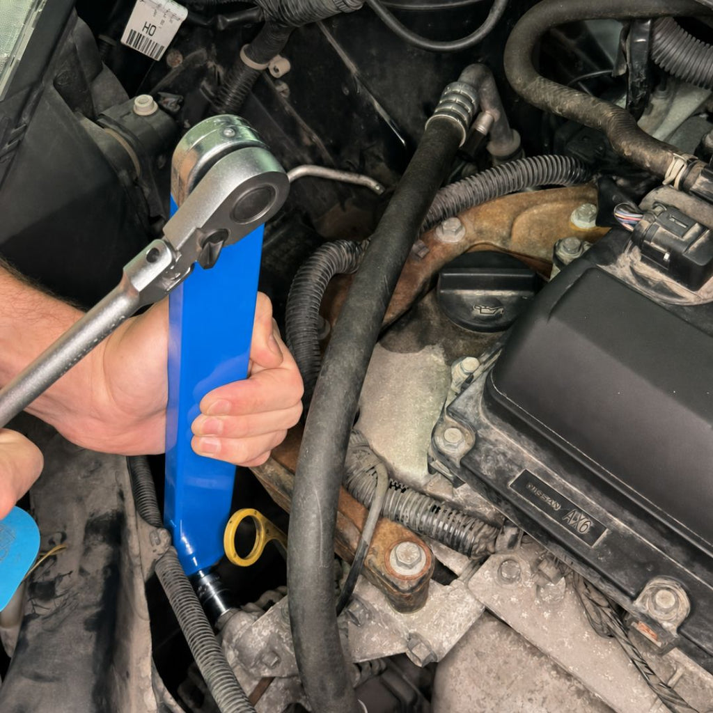 Offset extension wrench reaching a bolt deep in a car engine bay with a ratchet