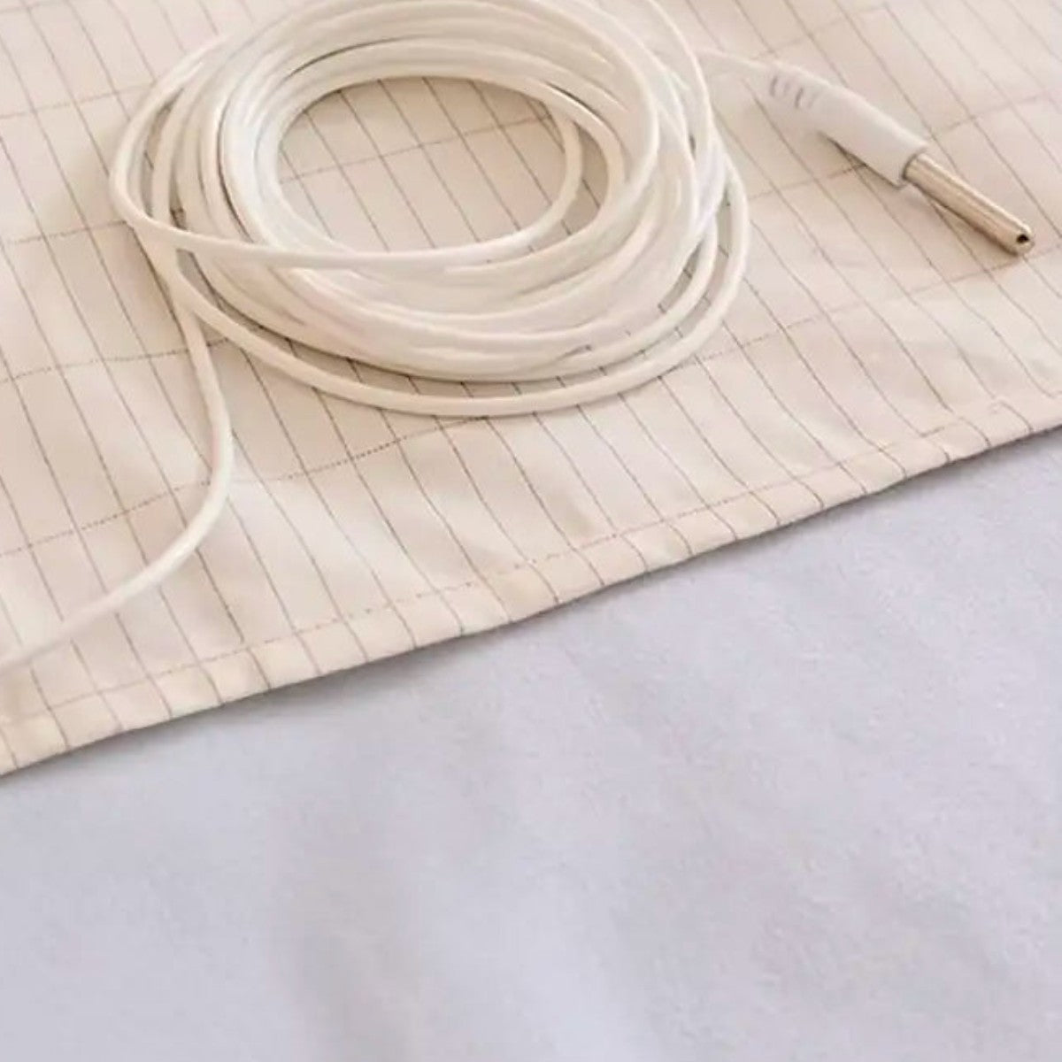 Coiled grounding connection cord on the cotton sheet