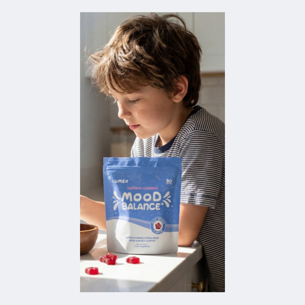 Boy taking a saffron gummy from a bowl next to the pouch
