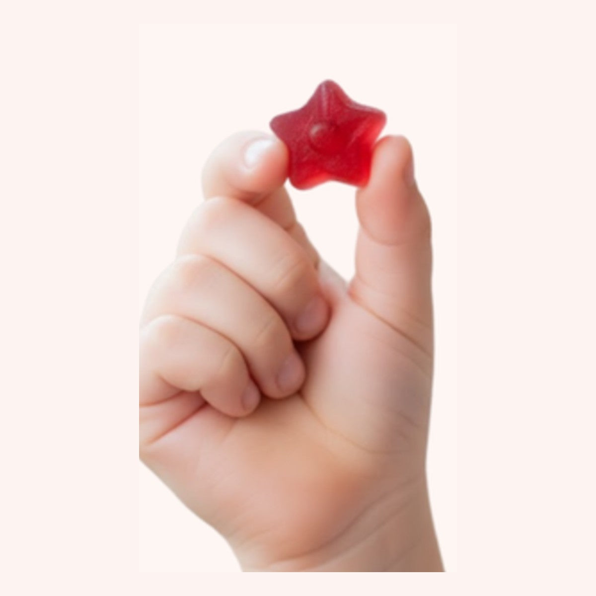Child's hand holding a star-shaped gummy